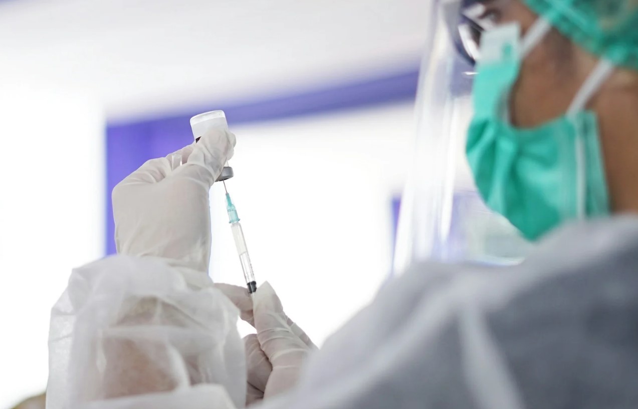 Billede af sundhedspersonale der forbereder vaccine til AJ Vaccines case.